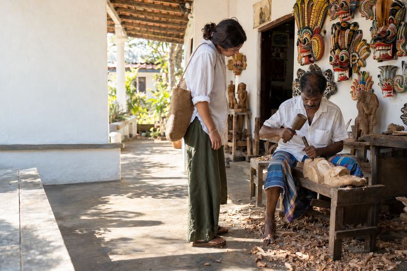 A mask carver at work on a sunny veranda in Ambalangoda