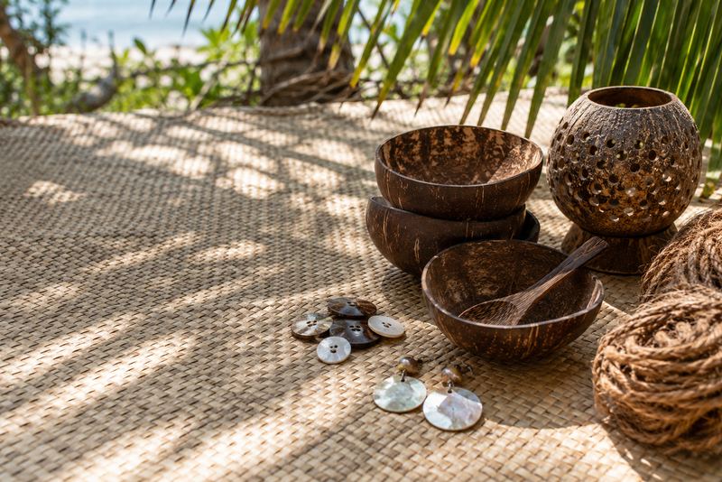 Coconut-shell bowls, spoons, buttons and earrings on a woven mat
