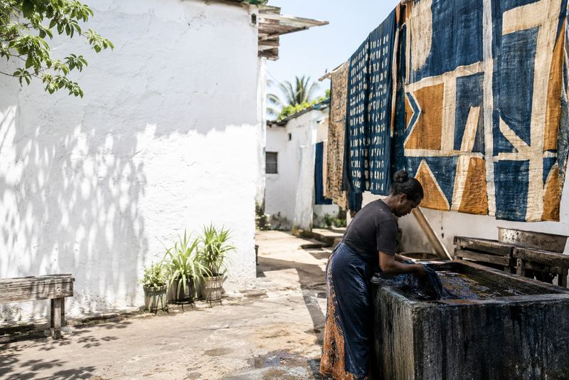 Modern indigo and ochre batik drying in a sunny courtyard