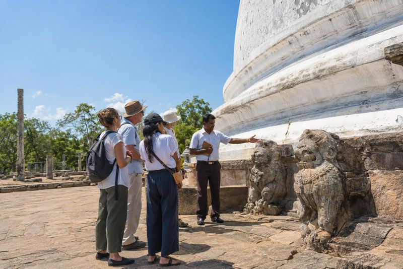 An archaeologist guiding visitors at an ancient stupa