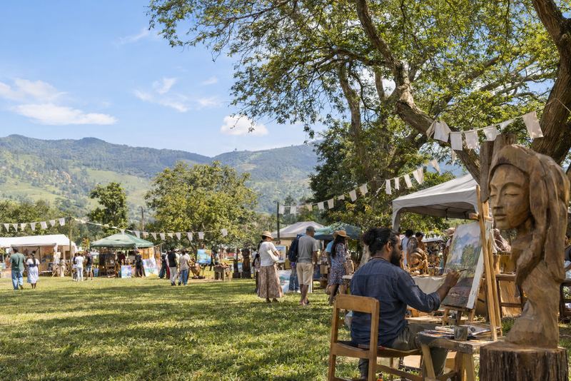 A sunny district arts festival with a painter and stalls