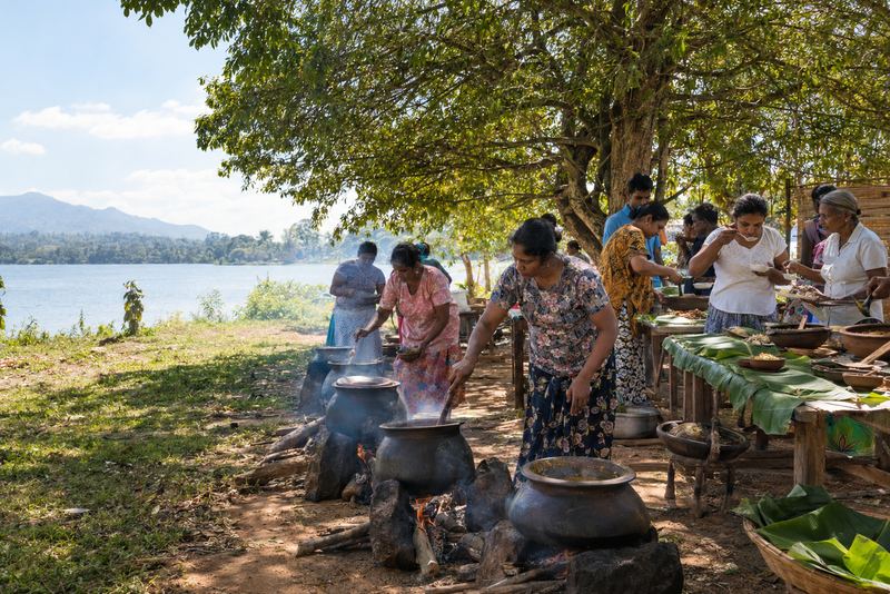 Visitors cooking curries for a village judging panel