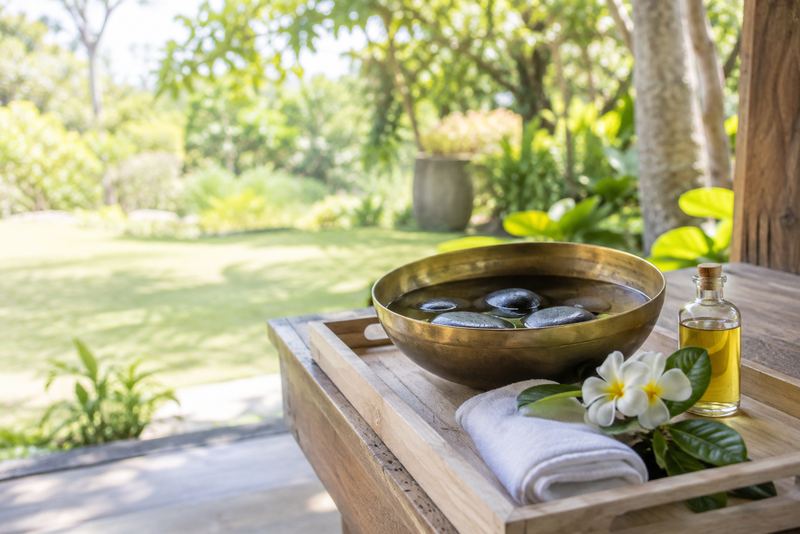 Granite massage stones in a brass bowl with frangipani
