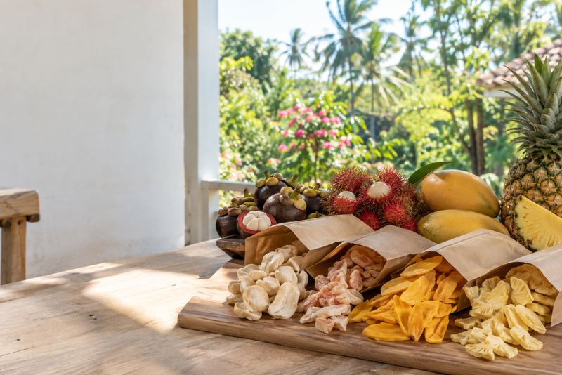Freeze-dried tropical fruit and fresh fruit on a sunny veranda table