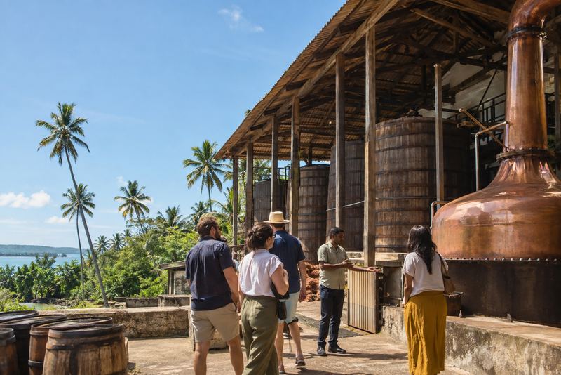 A guide showing visitors the vats and still at an arrack distillery