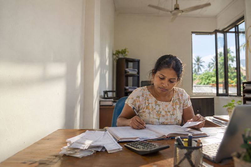 A ledger, receipts and a calculator on a bookkeeper's desk