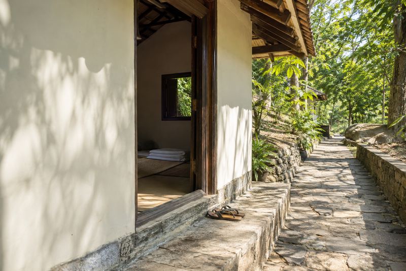Sandals at the door of a monastery guest room in the forest