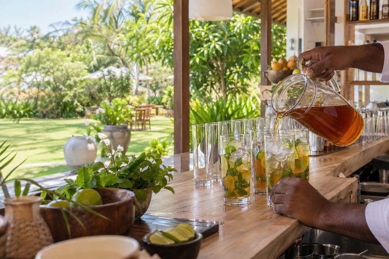 Tea concentrate poured into iced glasses at a sunny bar