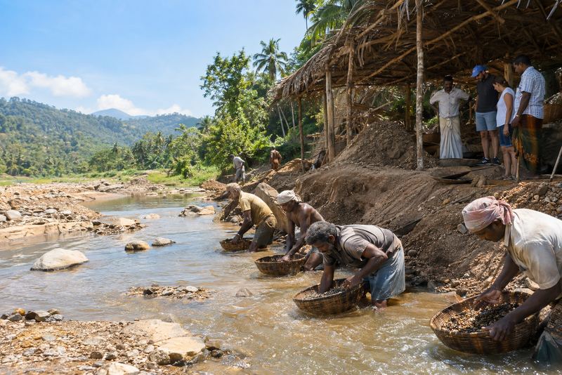Workers washing gem gravel as visitors watch in Ratnapura