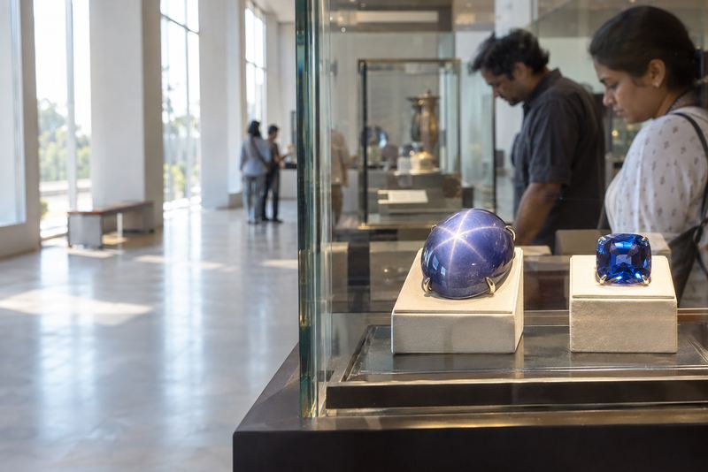 Visitors looking at two replica sapphires in a gallery case
