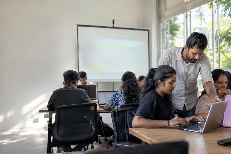 An instructor helping a student in a coding class