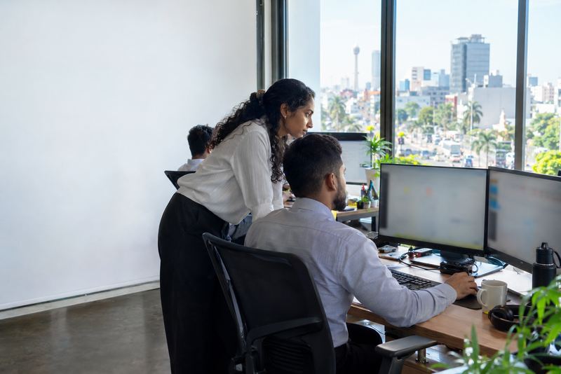 A security analyst watching screens in a bright office