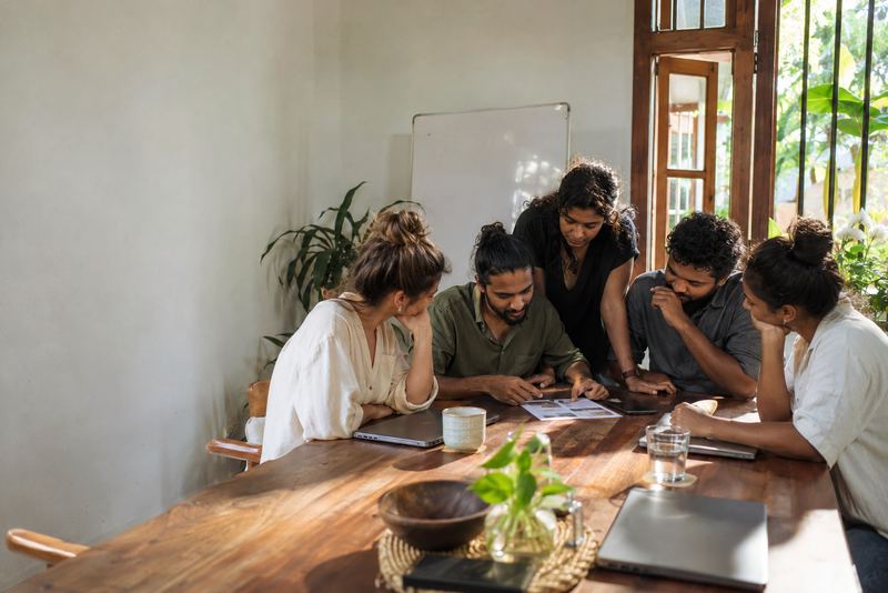 Freelancers reviewing one printed proposal at a table