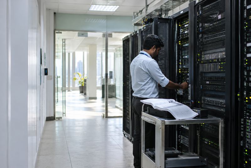 A technician servicing an old server rack in a bank