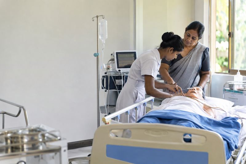 A student nurse practising on a manikin in a training ward