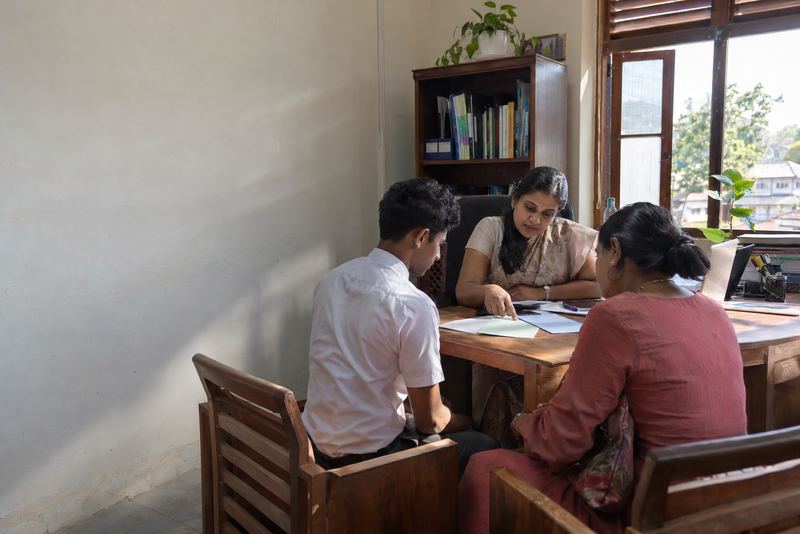 A counsellor talking with a parent and a teenager