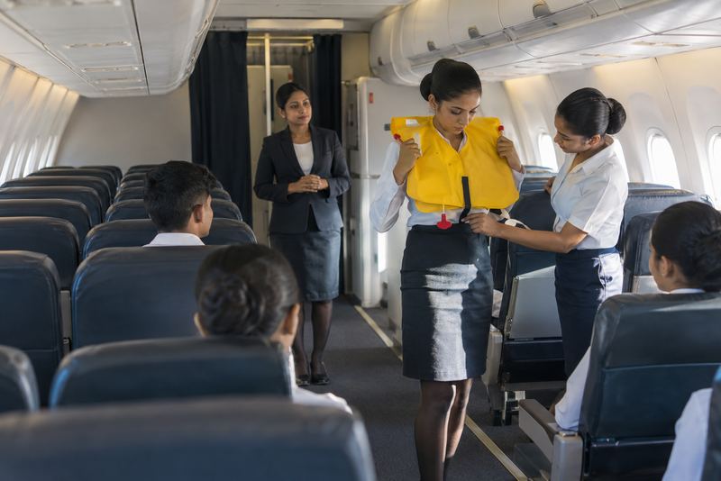 Trainee cabin crew practising a safety demonstration