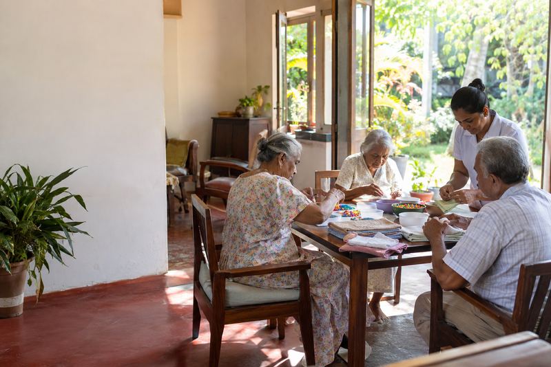 Elderly people sorting beads with a carer in day care