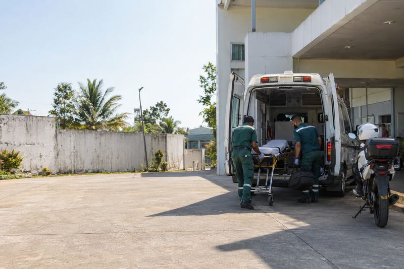 Paramedics loading a stretcher into an ambulance
