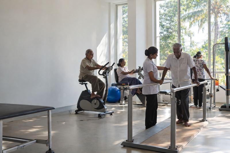 Older people exercising in a bright rehabilitation gym