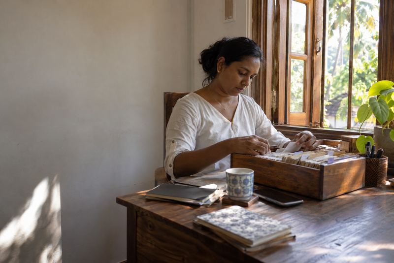 A coordinator sorting index cards into a wooden drawer