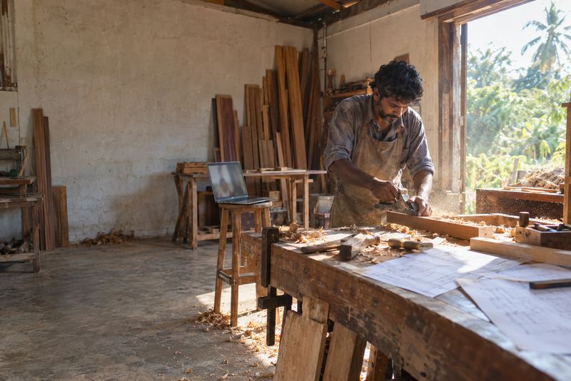 A carpenter talking to a mentor by video in his workshop