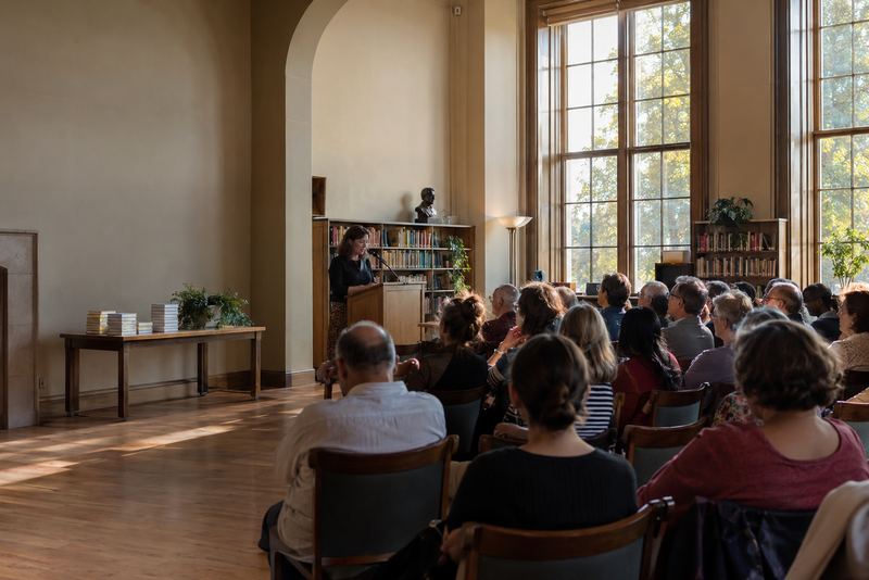 An audience listening to an author in a sunny library
