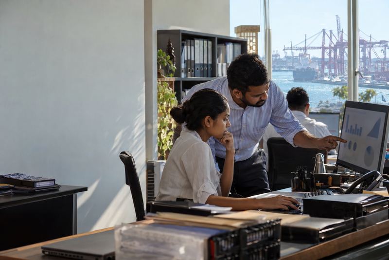 An intern learning from a colleague in a shipping office