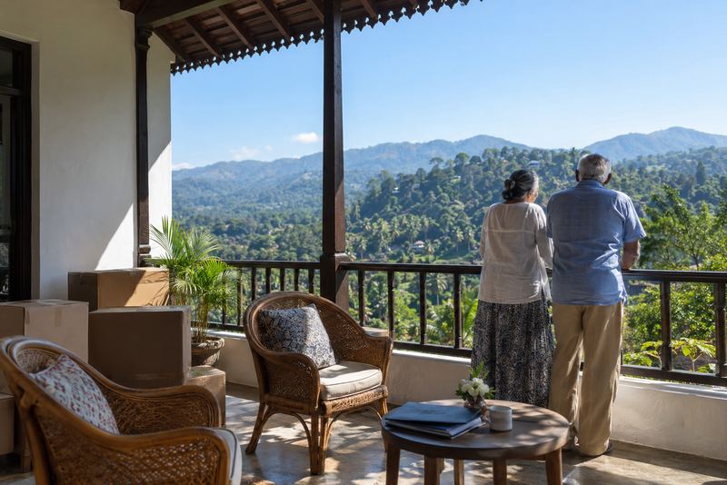A retired couple on a sunny hill veranda with packing boxes