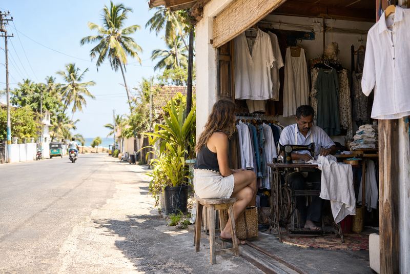 A tailor altering a visitor's shirt in a sunny beach town