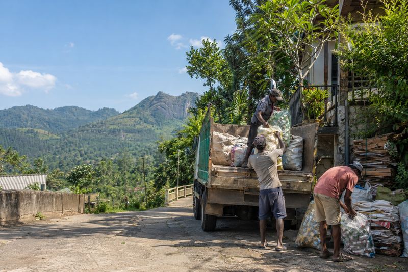 Workers collecting sorted recycling in a sunny Ella street