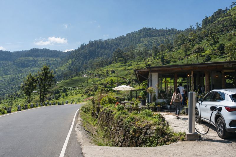 An electric car charging beside a tea-country café