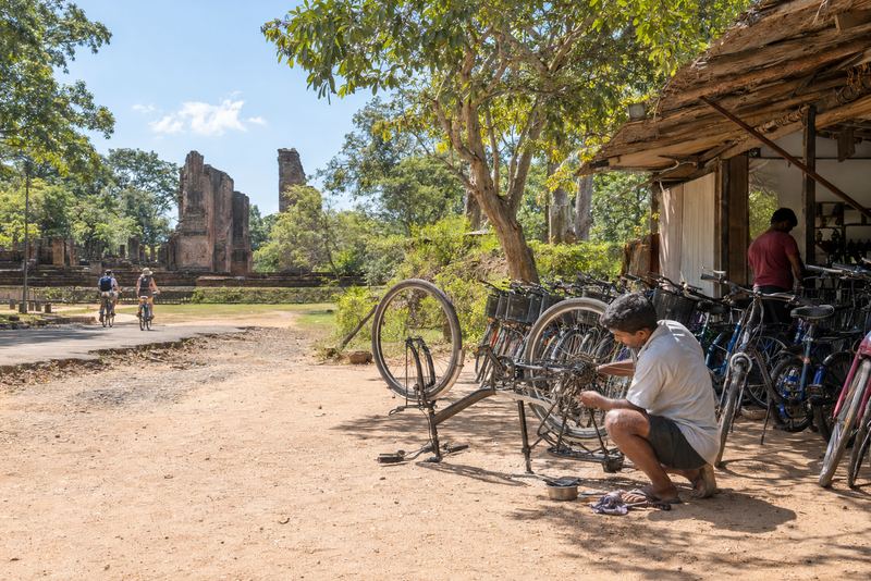 A mechanic fixing a hire bicycle in sunny Polonnaruwa