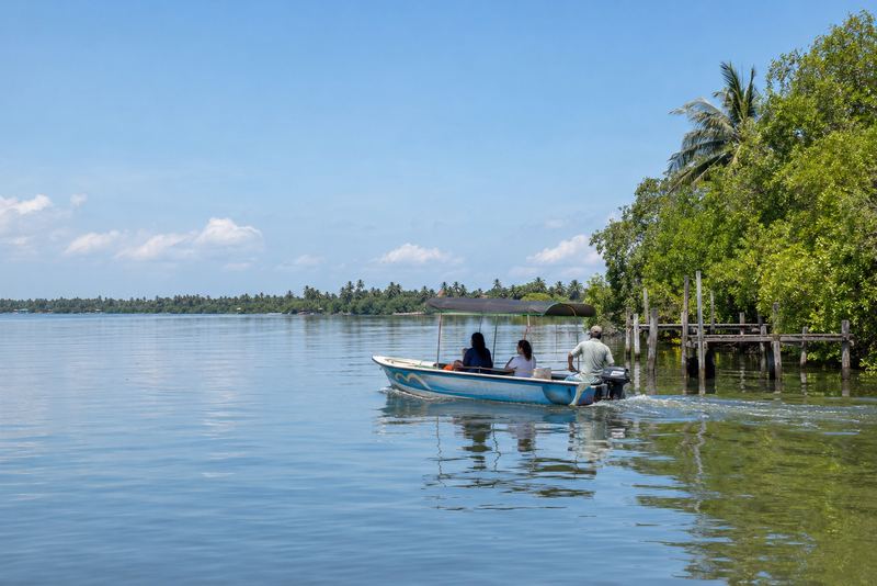 A canopied boat taxi crossing a sunny lagoon