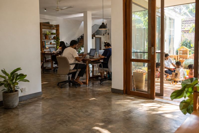 A bright shared workspace beside a children's playroom