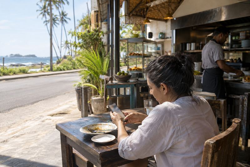 A diner writing a review at a sunny restaurant table