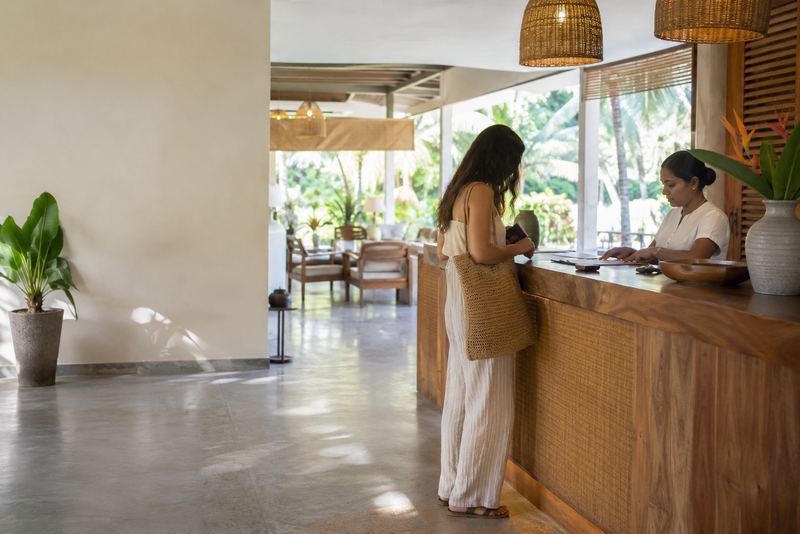 A guest at a sunny hotel reception with a notebook