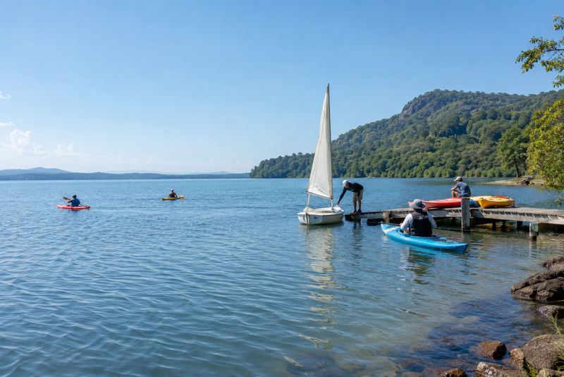 Kayaks and a dinghy on a sunny reservoir