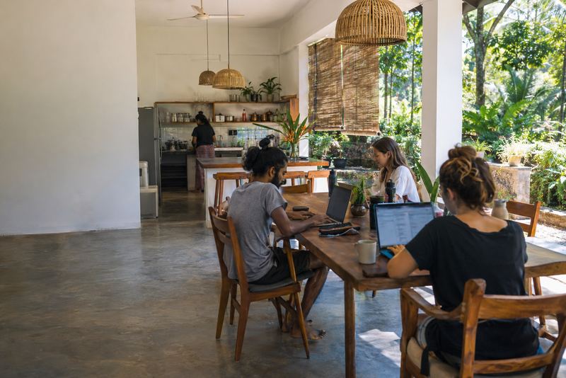 People working at long tables in a sunny Kandy co-working house