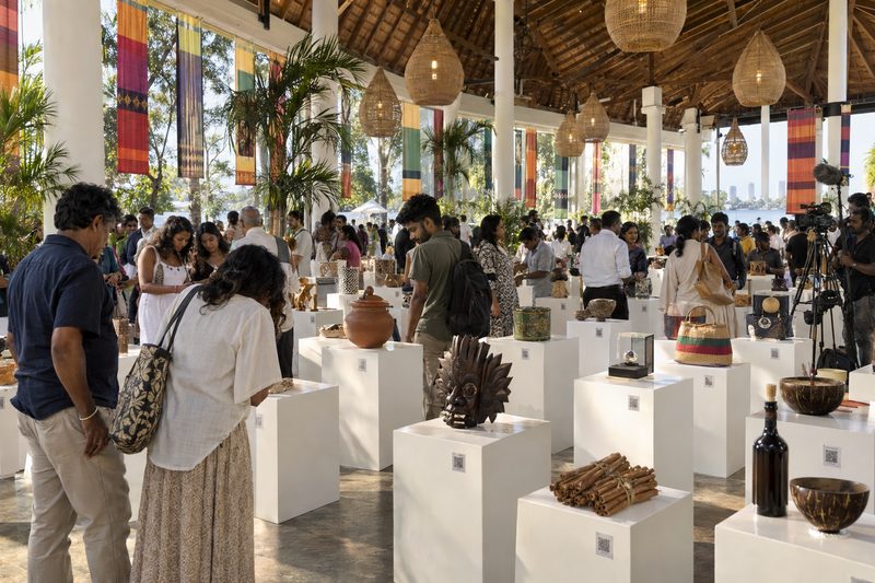 ප්රදර්ශනාගාරයක විවෘත කරන දිනය: සුදු කණු පේළි, එක් එක් කණුව මත කුඩා කාඩ්පතක් සමඟ එක් නිෂ්පාදනයක්, සහ චිත්රපට කණ්ඩායමක්
